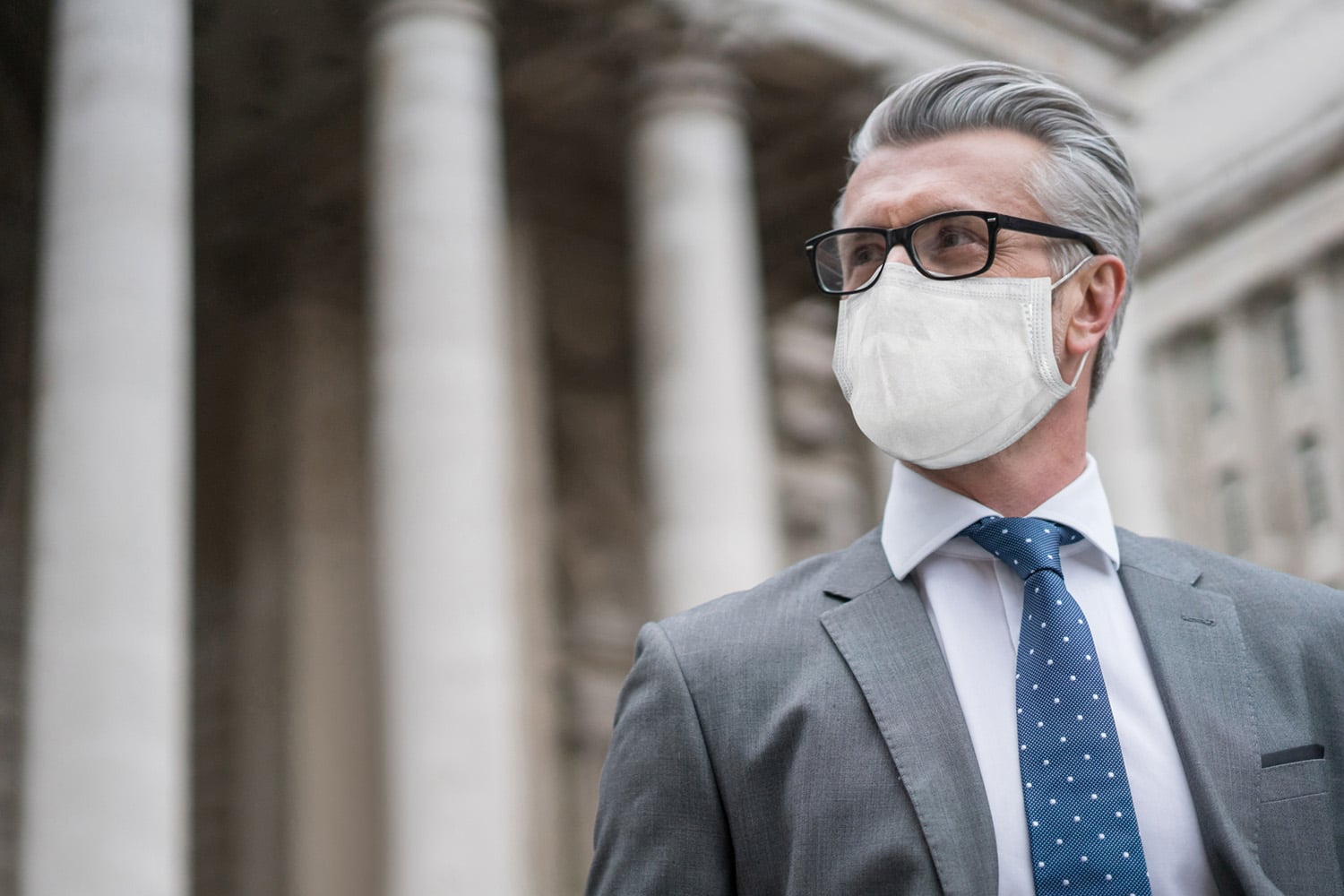 Business man on the street wearing a facemask to avoid COVID-19 Portrait of a successful business man on the street wearing a facemask to avoid COVID-19 â Pandemic concepts